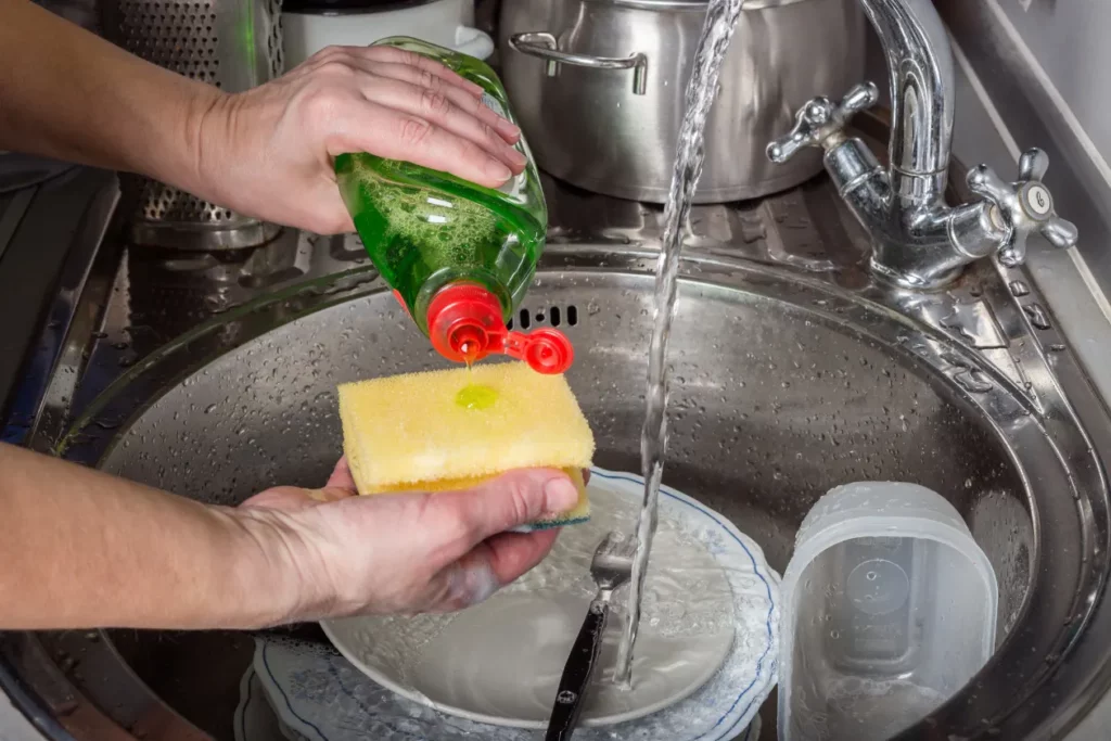 Pouring dishwashing liquid onto sponge