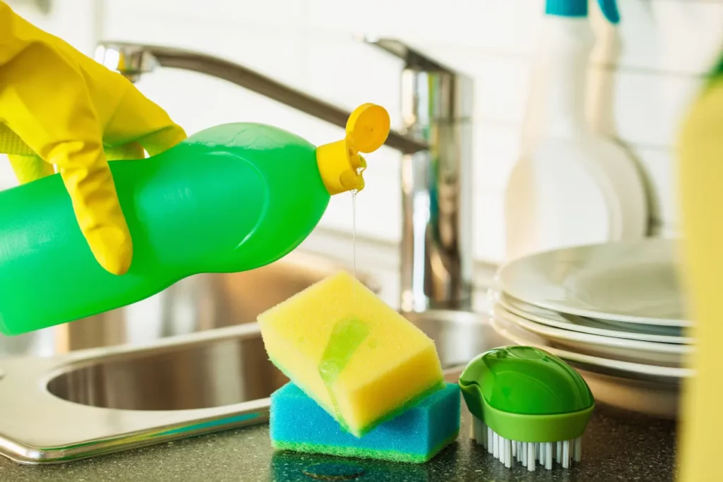 Washing dishes with sponge and dishwashing liquid