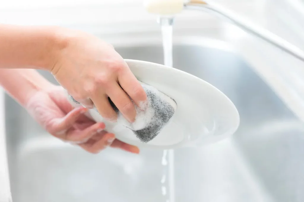 hand washing a dish with dishwashing liquid