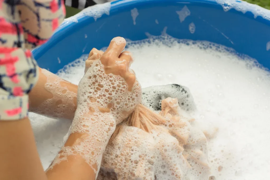 Hand washing chothes with high foaming detergent